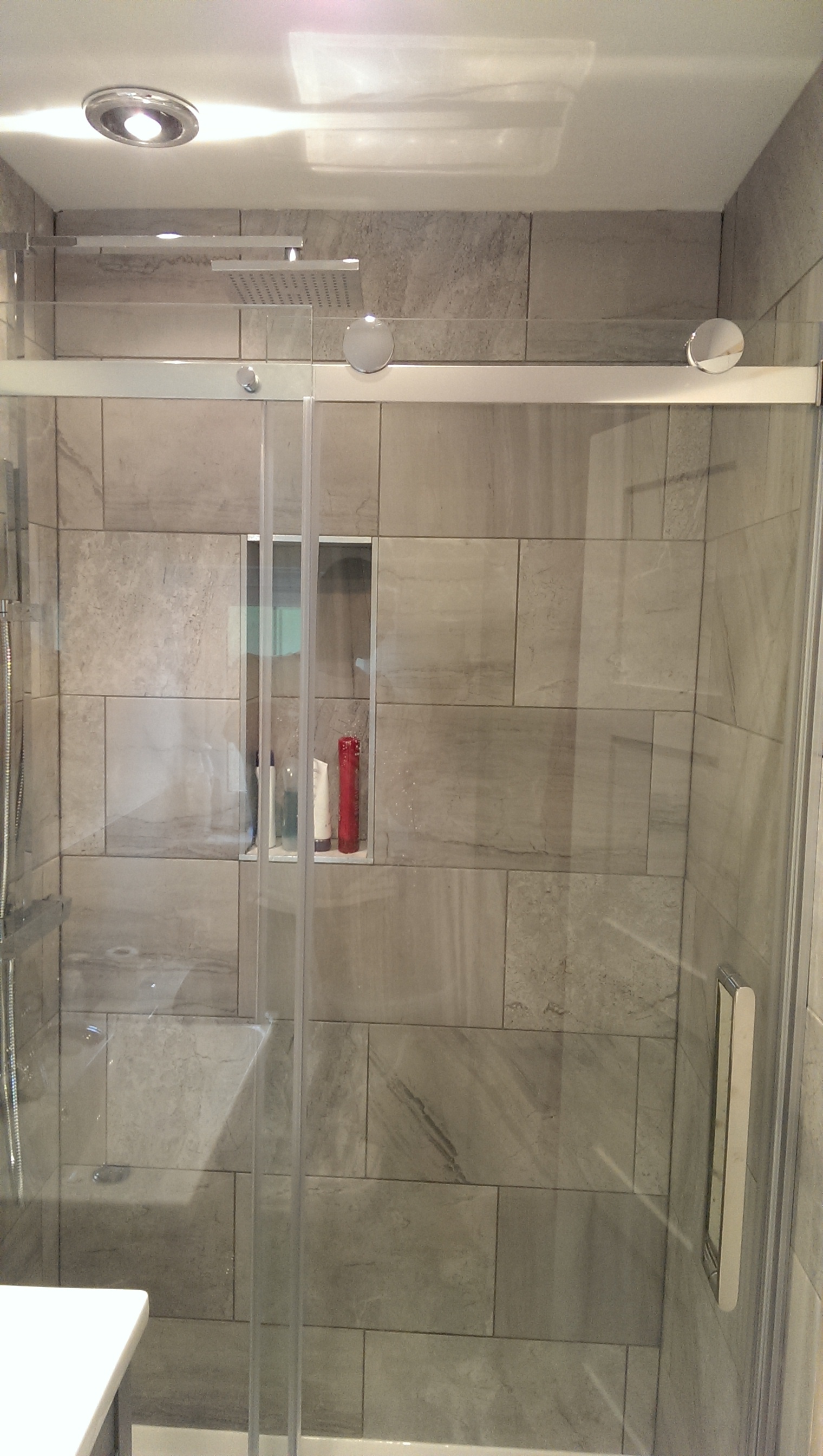 En-suite shower with grey stone-effect tiles and sliding glass door